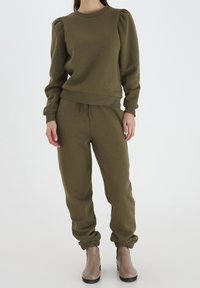 Olivgrünes Sweatshirt mit gepufften langen Ärmeln, gerippten Bündchen und Saum; kombiniert mit passenden Jogginghosen mit elastischen Knöchelabschlüssen.