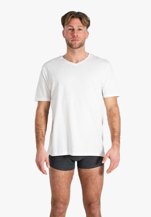 T-shirt en coton blanc à col en V avec des manches courtes, associé à un short boxer gris foncé. Design simple, coupe décontractée et texture douce.