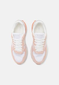 Sneakers rosa chiaro e bianchi con texture in rete e suede, dotati di lacci bianchi e dettaglio del logo sulla linguetta. Accentuati con arancione sul tallone.