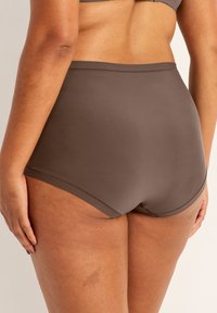 Valkoinen, korkeavyötäröinen alusvaate, joka on valmistettu sileästä ja pehmeästä kankaasta. Sisältää saumanvapauden ja mukavan vyötärön.