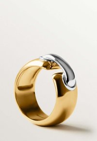 Anillo de metal dorado y plateado con un diseño suave y redondeado, con un acento de plata pulida en la parte superior y una banda gruesa.