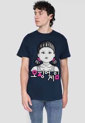 Navy blue T-shirt featuring a cartoon graphic of a girl with pigtails, pink accents, and Korean text below the illustration. Cotton material.