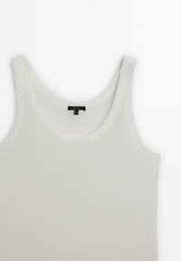 Top in cotone bianco senza maniche con scollatura tonda e spalline larghe. Il tessuto ha una trama liscia e una finitura sottile.