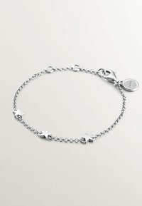 Pulsera de cadena de plata con cinco acentos en forma de estrella, un cierre de langosta y una pequeña etiqueta con logo en relieve. Acabado suave y pulido.