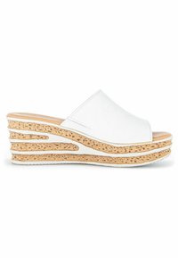 Sandales compensées blanches avec un dessus lisse, bout ouvert et plateforme texturée en liège. Présente un design incurvé et une semelle légère.