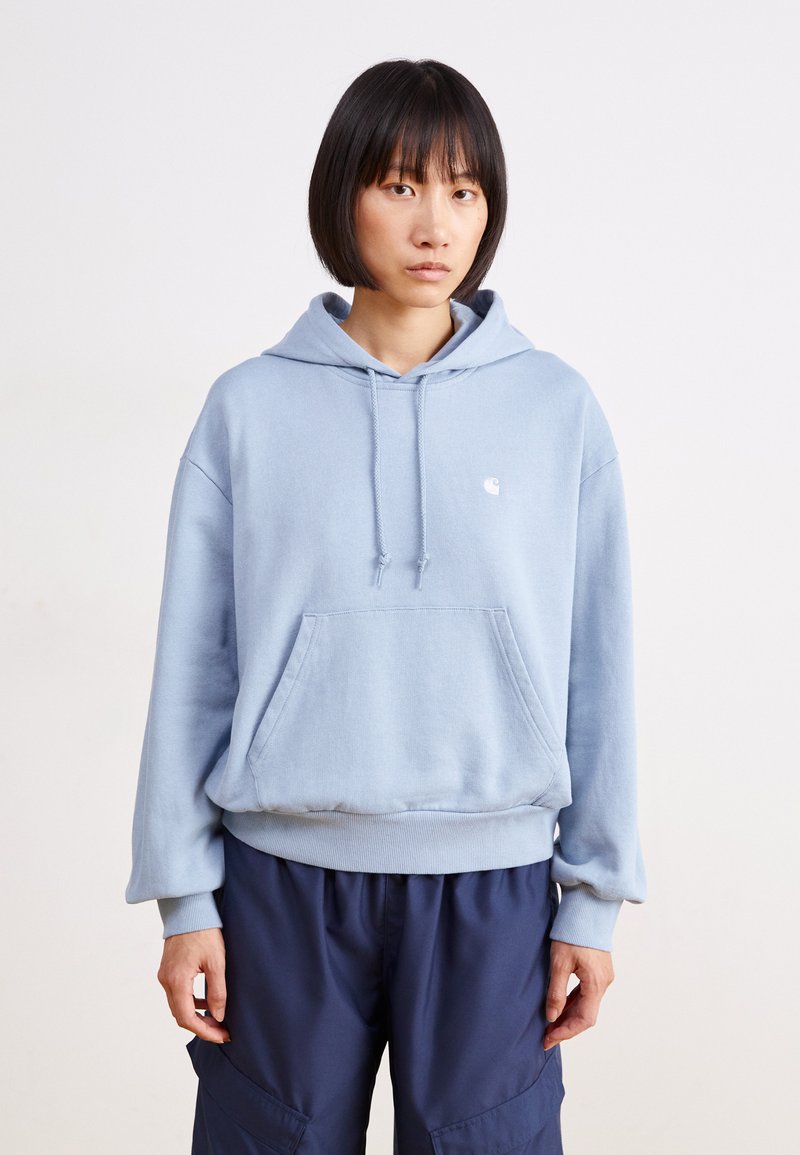 Light blue hoodie with a front pocket, drawstrings, and ribbed cuffs. Pairing with dark navy cargo pants, featuring a relaxed silhouette.