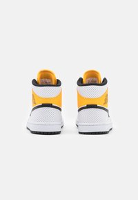 Wysokie trampki z perforowanej białej skóry, z żółtymi i czarnymi akcentami, wyściełanym kołnierzem i kontrastującą gumową podeszwą.