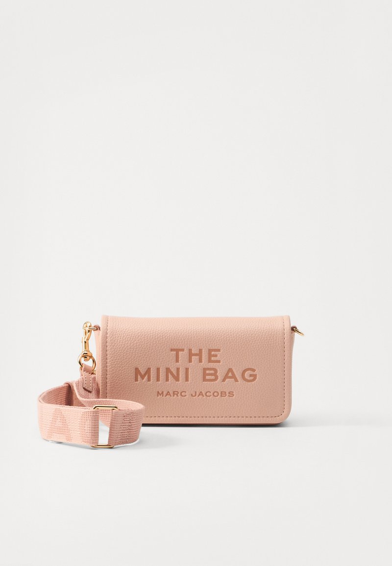 Růžová kožená mini taška se zlatými detaily. Text "THE MINI BAG" a "MARC JACOBS" vyražený na přední straně. Obsahuje odpovídající popruh.