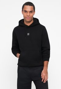Sweat à capuche en coton noir avec une poche avant, un cordon de serrage pour la capuche et un logo blanc "II" sur la poitrine. Poignets et ourlet côtelés pour un ajustement confortable.