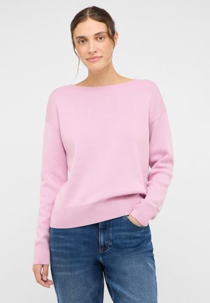 Light pink sweater with a loose fit, boat neckline, ribbed cuffs, and hem. Paired with blue denim jeans, emphasizing casual comfort.