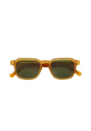Lunettes de soleil rectangulaires teintées en jaune avec des verres verts. Monture en plastique avec un subtil motif détaillé. Forme carrée et branches épaisses.