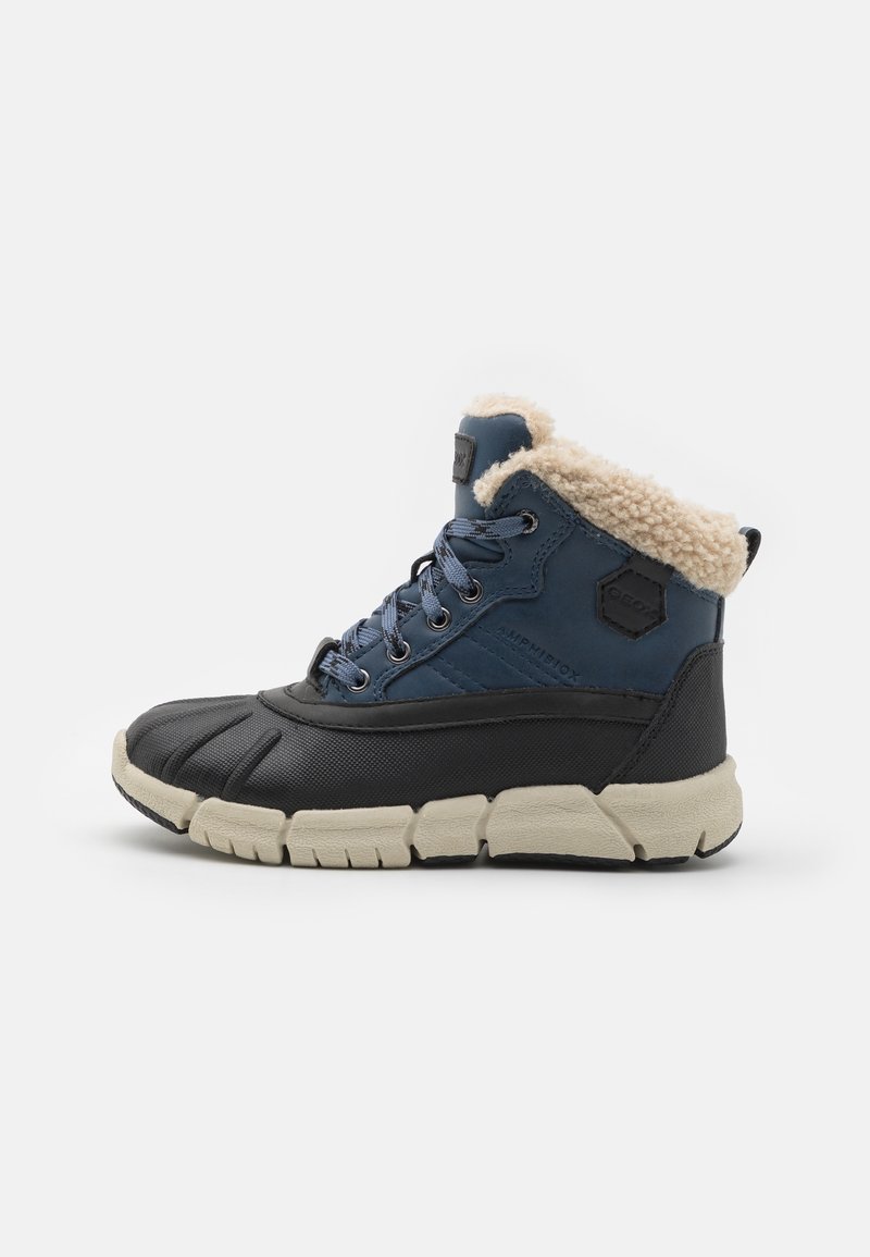 Bottes mi-hautes bleu foncé et noires, avec une semelle en caoutchouc texturée, une doublure en fausse fourrure et des lacets contrastants ornés d'un logo hexagonal.