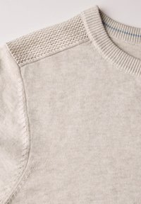 Maglione color beige chiaro con un motivo a maglia testurizzata sulle spalle, colletto a coste e tessuto morbido con una finitura liscia.