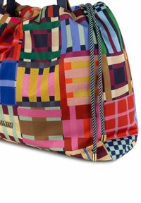 Kleurrijke trekkoordtas met een patchworkpatroon van vierkanten en strepen in rood, roze, blauw, groen, geel en bruin tinten.