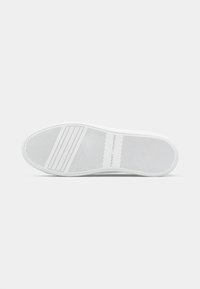 Semelle de sneaker blanche avec une texture antidérapante, orteil arrondi et imprimé de logo. Comprend des nervures en caoutchouc horizontales et verticales pour une meilleure adhérence.
