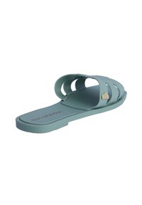 Una chancla de color verde claro hecha de plástico suave, con dos bandas superpuestas, una suela plana y un pequeño acento en forma de corazón en la banda exterior.