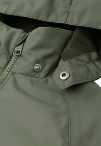 Giacca verde, resistente all'acqua, con chiusura a zip, bottoni a pressione e fodera in rete. Presenta cuciture rigide e un design classico.