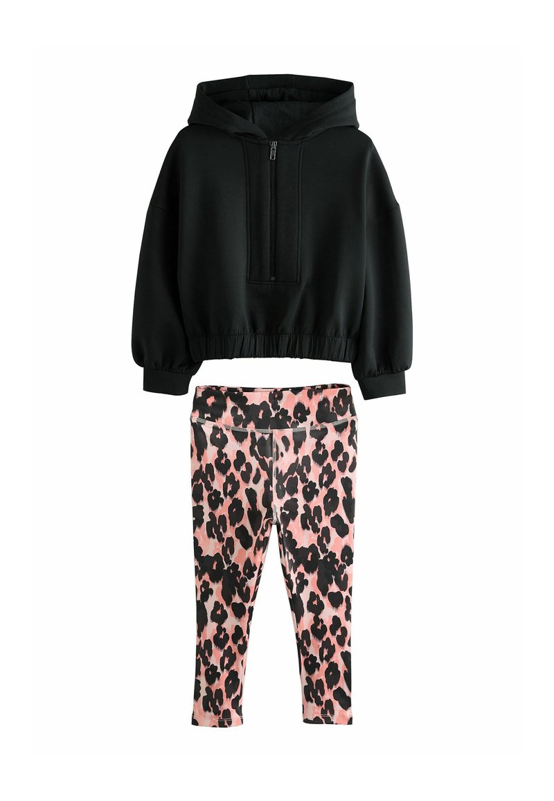 Sweatshirt noir à capuche avec une fermeture éclair à l'avant et des poignets élastiques, associé à un legging rose avec un motif léopard noir.