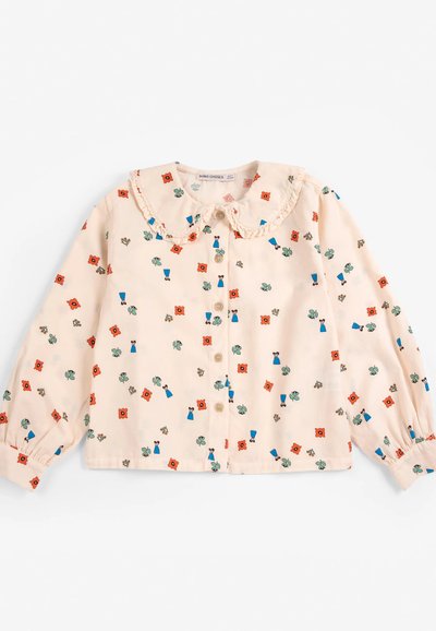 Blouse rose pâle à manches longues avec col à volants, boutons sur le devant et petits motifs floraux et feuillages rouges, bleus et verts.
