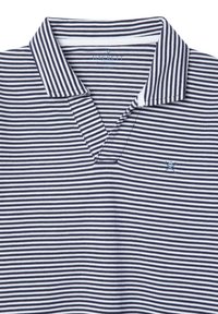 Polo-shirt rayé bleu marine et blanc avec col rabattu, doté d'une patte de boutonnage à trois boutons et d'un petit logo brodé sur la poitrine.