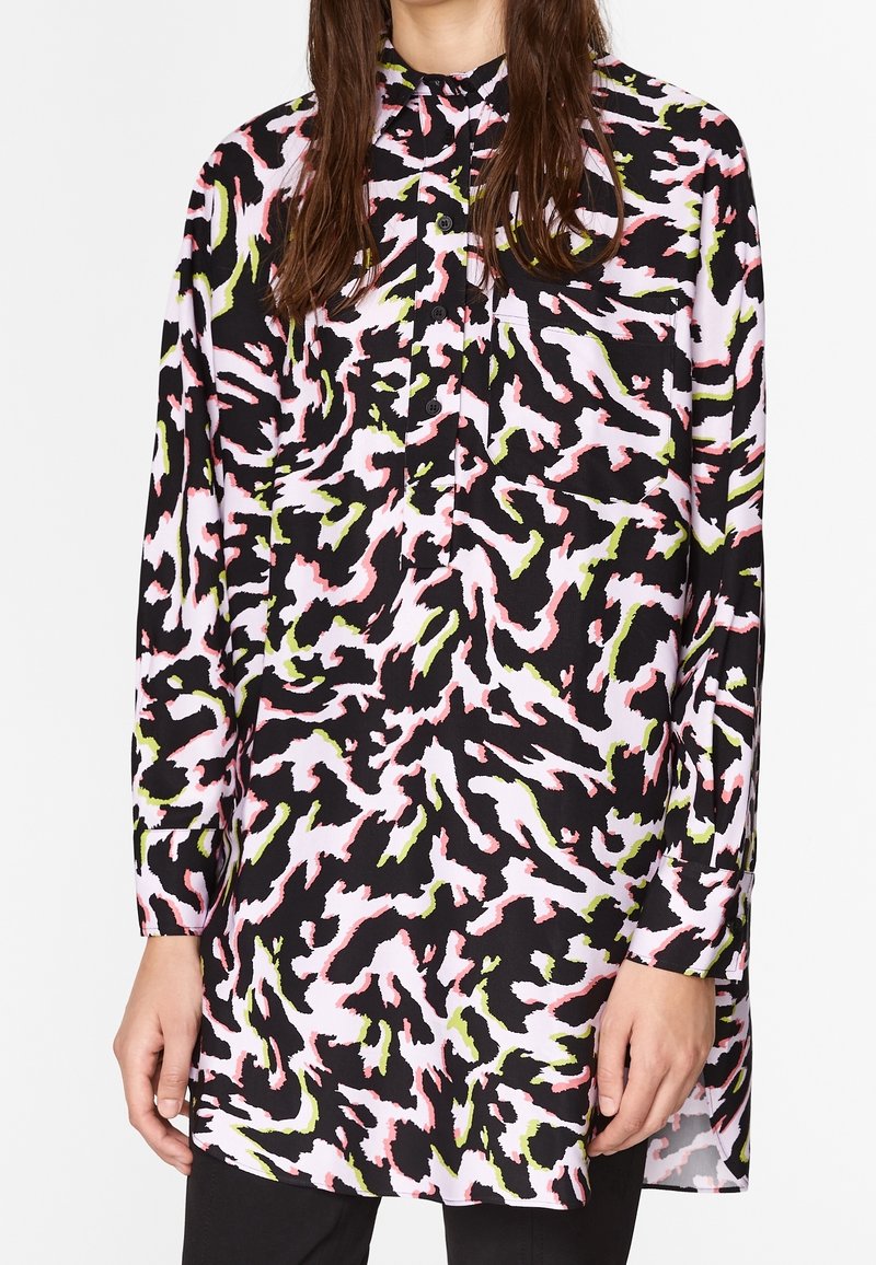 Košile s dlouhým rukávem na knoflíky, která má černý základ s abstraktním vzorem v růžové, bílé a zelené barvě. Lehká, hladká látka, uvolněný střih.