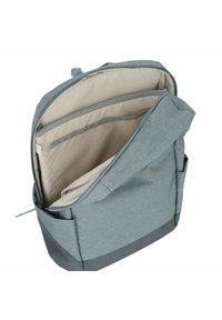Zaino in tessuto azzurro chiaro con un interno beige evidente. Presenta più scomparti con cerniera e una tasca laterale per ulteriore spazio di archiviazione.