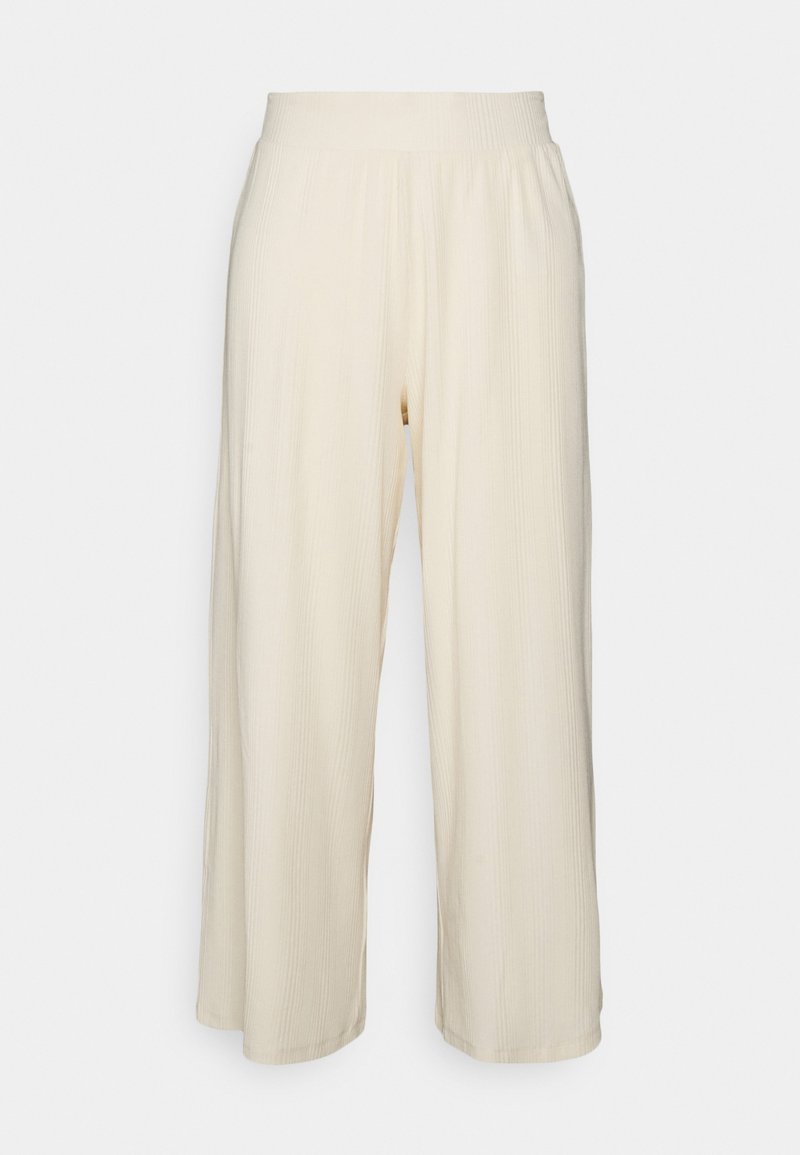 Pantalon large couleur crème avec tissu texturé et taille élastique, présentant des côtes verticales pour un détail supplémentaire.
