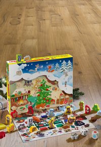 Träadventskalender med färgglada figurer, med en snöklädd design, julgran och festliga illustrationer.