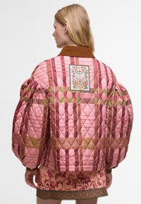 Κουβερτίνα ροζ τζάκετ με καφέ σιέρια, διακοσμημένο με φλοράλ απλικέ και γεωμετρικά σχέδια σε πράσινους και καφέ τόνους. Φουσκωτά μανίκια και υφή.