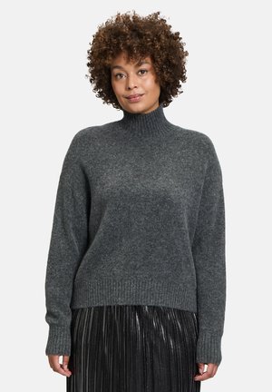 Dunkelgrauer, gestrickter Rollkragenpullover mit gerippten Bündchen und Saum, kombiniert mit einem plissierten, metallischen Rock. Weiche Textur und lockere Passform.