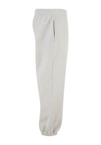 Lys grå sweatpants med elastisk talje, side lommer og skråede manchetter. Lavet af blødt stof med en glat tekstur.