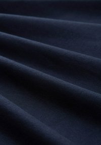 Marineblauwe stof met een gladde textuur, met subtiele vouwen en kreuken, die een uniforme kleur toont zonder patronen of accenten.