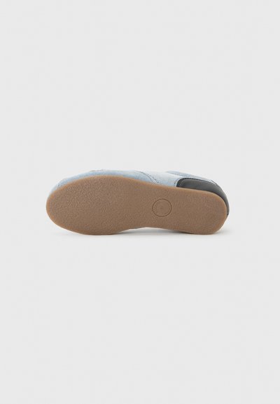Footwear featuring a light blue denim upper with gray accents, rubber sole, and textured tread for grip. Heel has a curved edge.