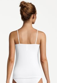 White camisole with thin adjustable straps, smooth texture, straight hem, and a simple design without patterns or embellishments.