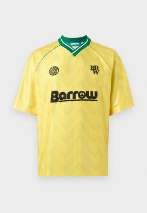 Maglia sportiva gialla con collo verde, logo nero "Barrow" sul petto e due piccoli loghi neri sulla parte superiore anteriore.