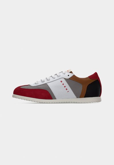 Baskets en daim rouge et gris avec des accents en cuir blanc, talon en cuir marron et semelle en caoutchouc texturée. Elles comportent des lacets et un détail de logo.