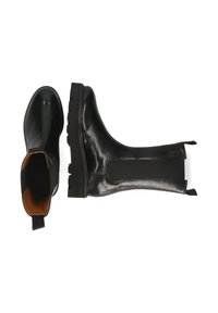 Botas Chelsea de cuero negro con paneles laterales elásticos, suelas resistentes y tiradores, mostradas desde vistas superior y lateral sobre fondo blanco.
