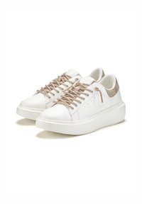 White sneakers with textured beige suede accents, round toe, flat sole, and metallic laces. Smooth upper surface, minimalist design.