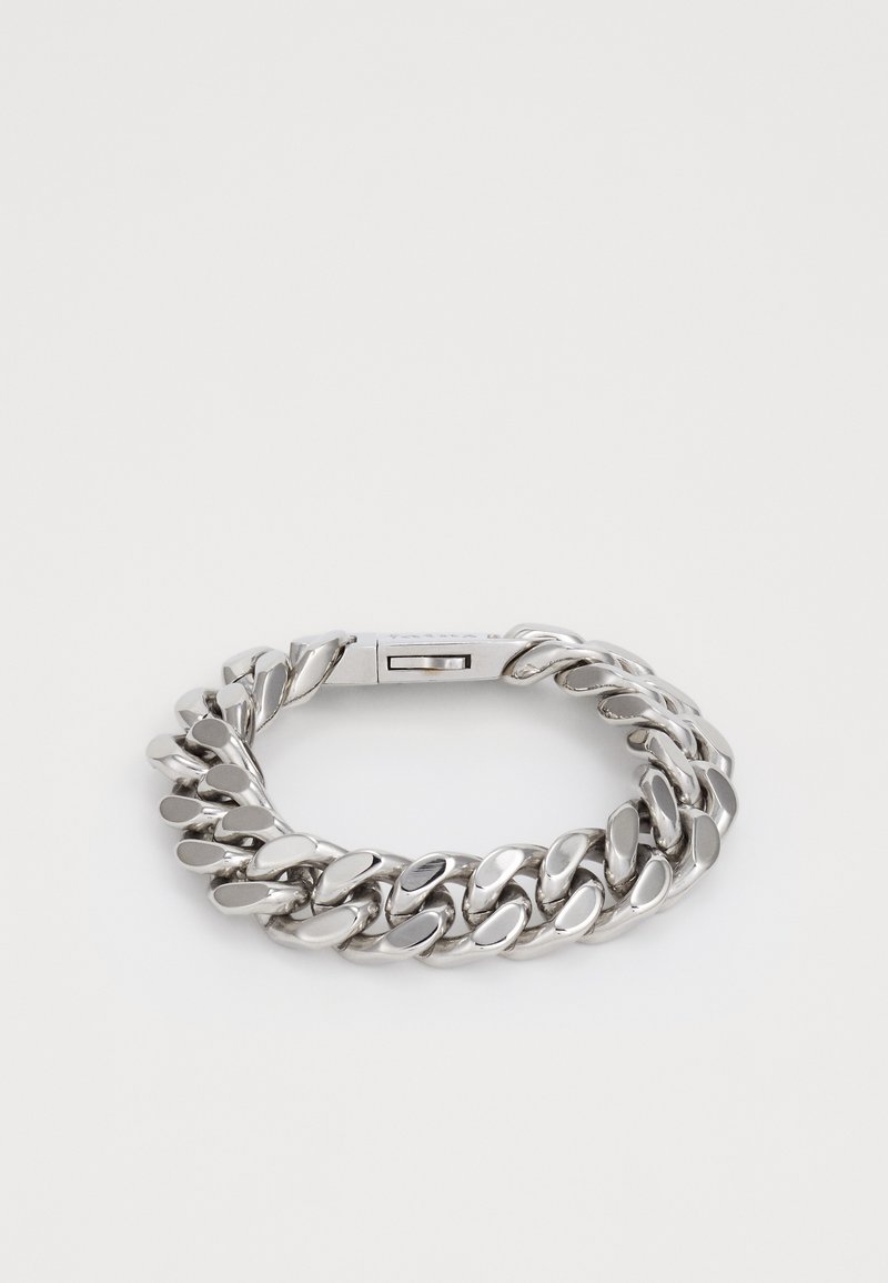 Dikke zilveren kettingarmband met gepolijste, ronde schakel en een rechthoekige sluiting op een witte achtergrond.