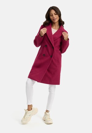 Fuchsia double-breasted coat with large black buttons, wide lapels, and side pockets. Paired with white leggings and chunky cream sneakers.
