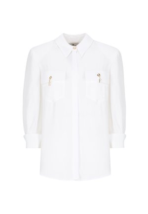 Blusa bianca, tessuto leggero, design con bottoni, maniche arrotolabili, due tasche sul petto con dettagli dorati e logo discreto.