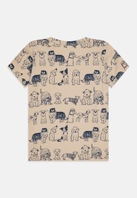 Beige t-skjorte med et mønster av forskjellige hundeillustrasjoner i mørkeblått. Korte ermer, rund hals, avslappet passform, og en glatt tekstur.