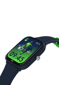 Marinsport smartwatch med rektangulär skärm som visar en fotbollsgrafik, gröna accenter och en silverfärgad sidoknapp.