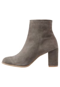 Šedá semišová kotníková bota s kulatou špičkou a 7,5 cm blokovým podpatkem. Hladká textura, bezproblémový design a neutrální tón vhodný pro různé outfity.