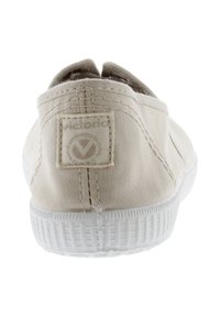 Scarpa beige in tela slip-on con suola in gomma bianca texturizzata. Presenta una cucitura sul retro e un'etichetta del marchio intrecciata sul tallone.