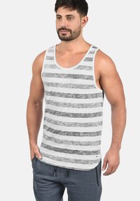 Grå og hvitstripet tanktop, laget av bomull, avslappet passform, brede stropper, rund hals, kombinert med mørkegrå joggebukser, uformell stil.