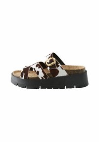 Sandalias con plantilla de corcho, parte superior con un patrón de vaca marrón y blanco, suela de goma negra, doble tira entrecruzada y hebilla dorada ajustable.