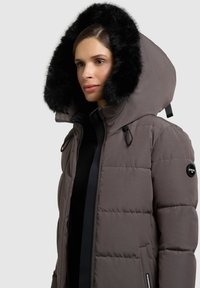 Pufferjack in een gedempt grijs met een afneembare zwarte faux fur capuchon, gewatteerde textuur en verstelbare trekkoorden. Zakken aan de zijkant en logo-detail.