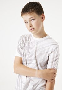 Witte korte mouwen T-shirt met een geometrisch bladdessin in lichtgrijs. Zachte stof met een ronde halslijn en een standaard pasvorm.