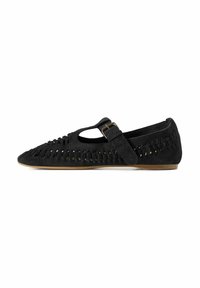 Zapato plano de ante negro con punta afilada, diseño recortado, detalles trenzados y cierre de hebilla lateral; suela de perfil bajo.